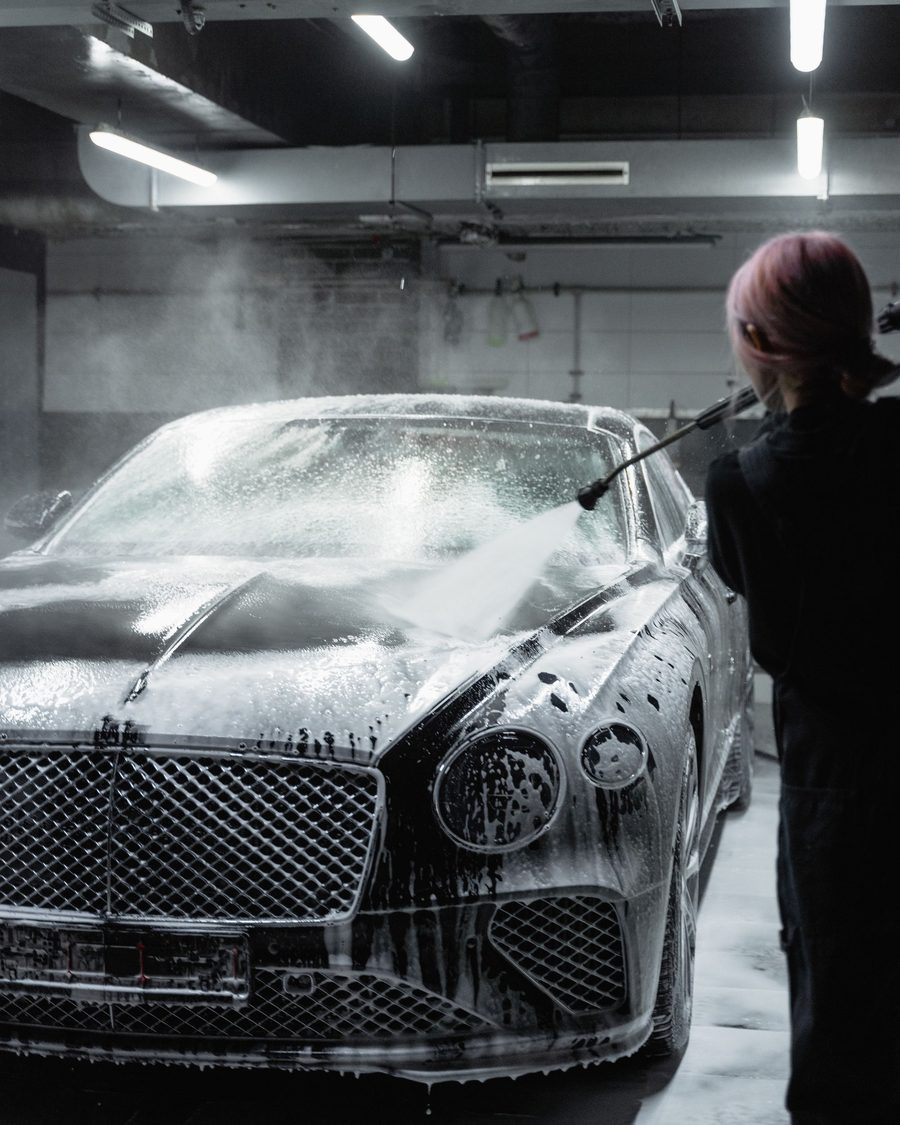 Foam-covered luxury car under garage lights