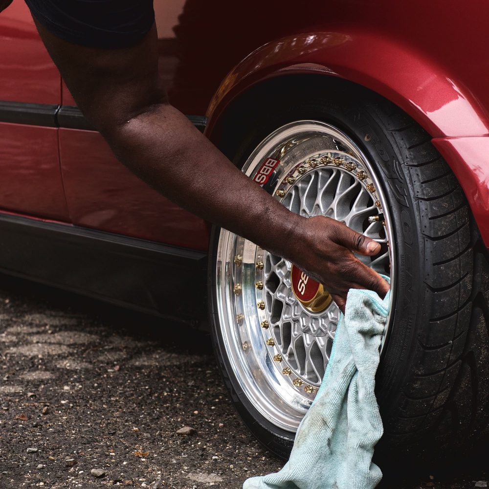Hand cleaning the spokes of a wheel with a cloth